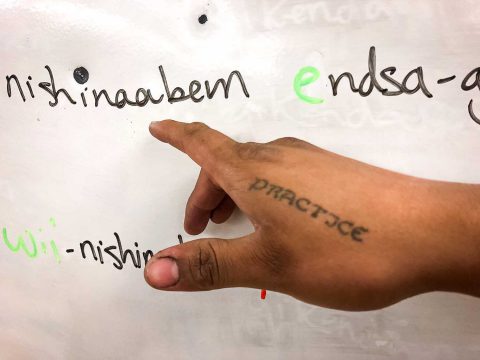 Un tatouage sur la main du professeur Ninaatig Pangowish tient lieu d’appel permanent à la pratique (« pratice ») de la langue