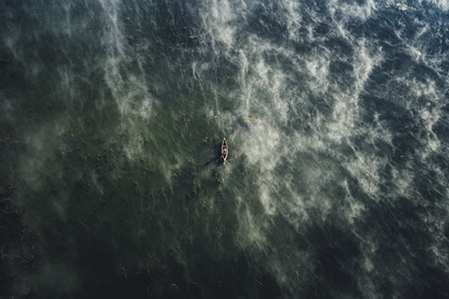 Aerial shot of someone canoeing on a lake