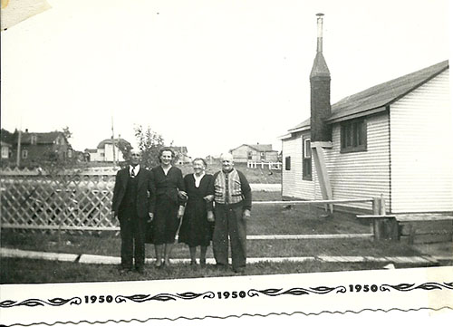 Four people standing in front of an old building