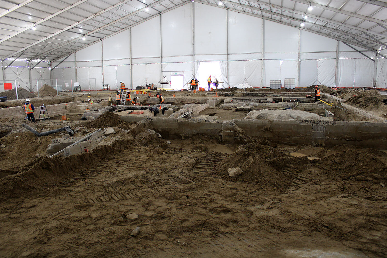 Excavations underway beneath a large tent structure during 2023